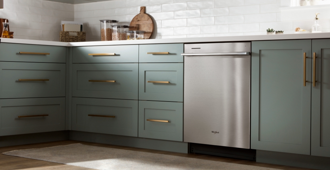 stainless steal dishwasher next to light green counters